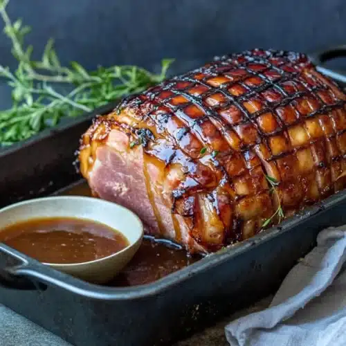 FAQ : 1 Delicious Brown Sugar Rum Baked Ham glistening in a roasting pan.