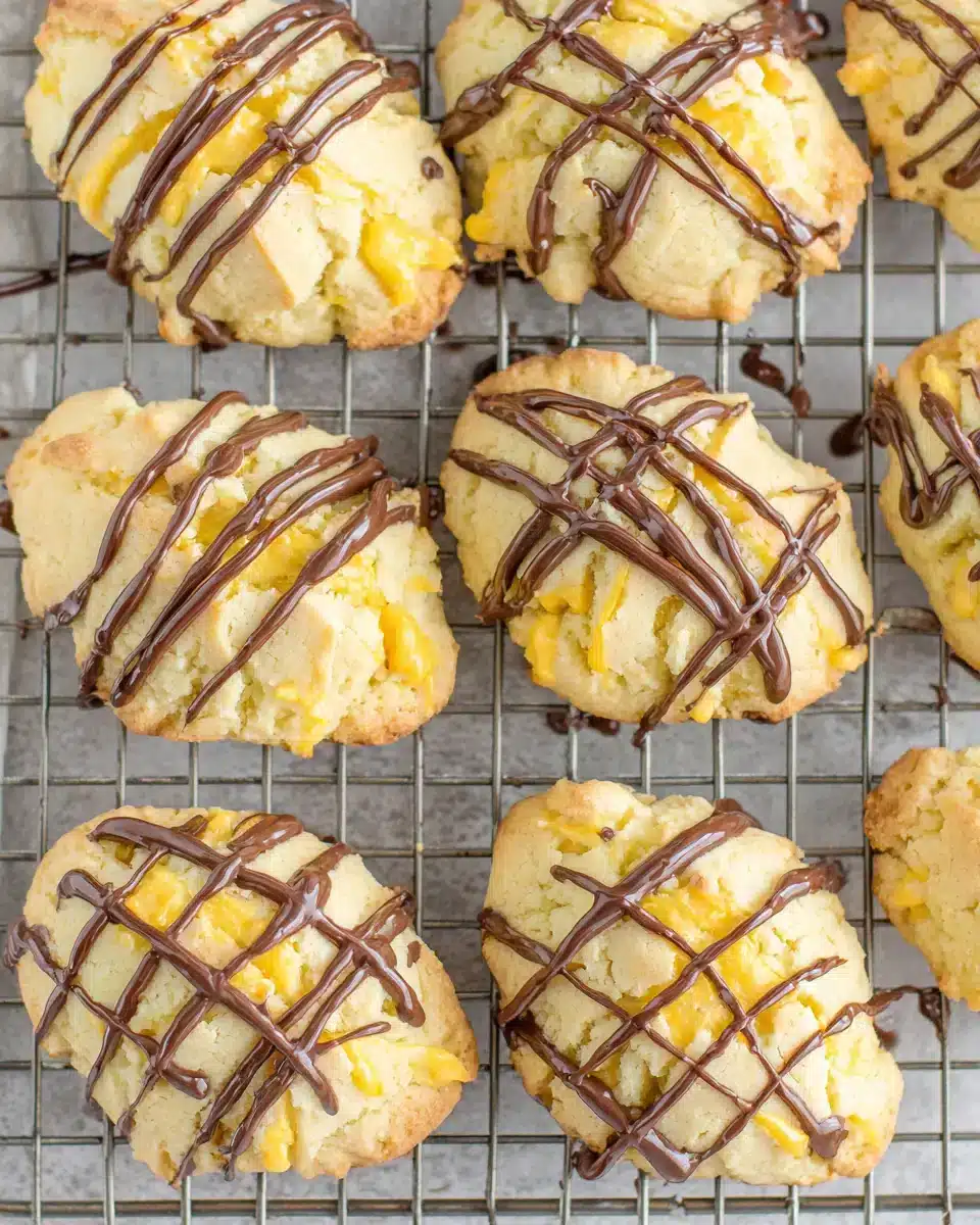 Delicious Cannoli Cookies with chocolate drizzle displayed on a rack.