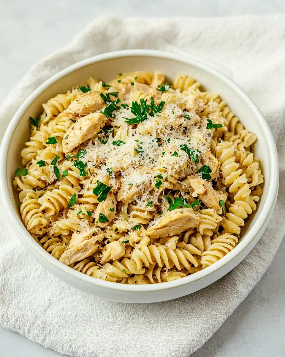 Crockpot Garlic Parmesan Chicken Pasta in a bowl with parsley garnish.