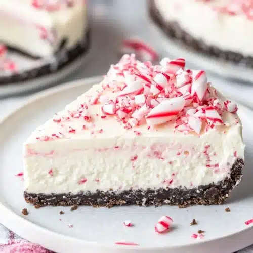No Bake Peppermint Bark Cheesecake 1 No Bake Peppermint Bark Cheesecake slice with candy cane topping