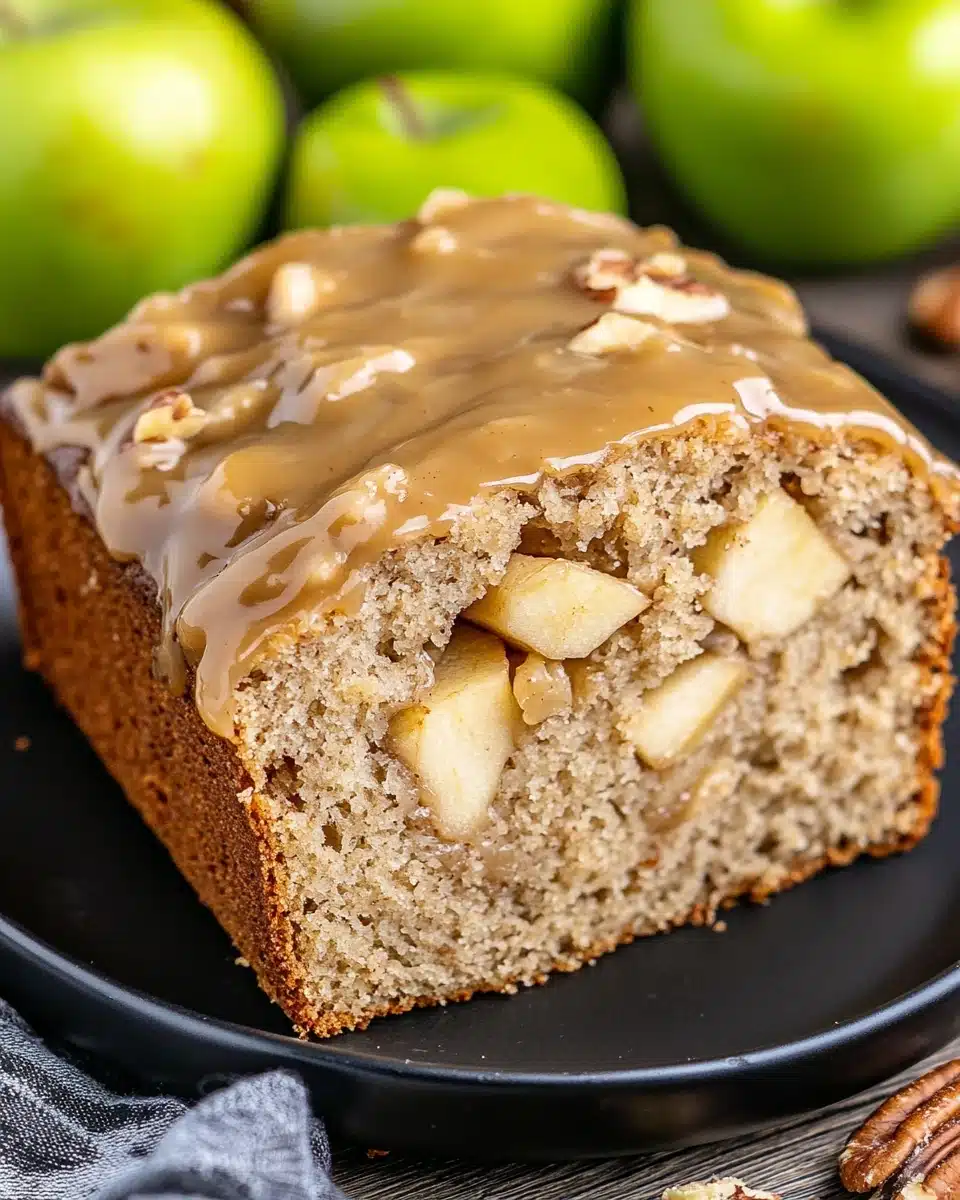 Caramel Apple Bread with rich glaze and fresh apples on a plate.