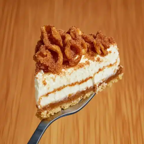 Delicious Churro Cheesecake slice with creamy filling and golden crust.