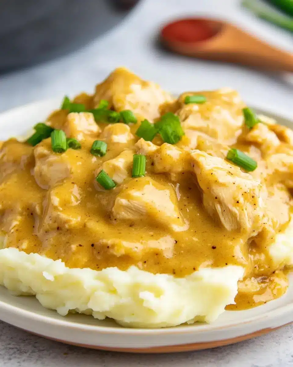 Crock Pot Chicken and Gravy Delight Crock Pot Chicken and Gravy over mashed potatoes with green onions.