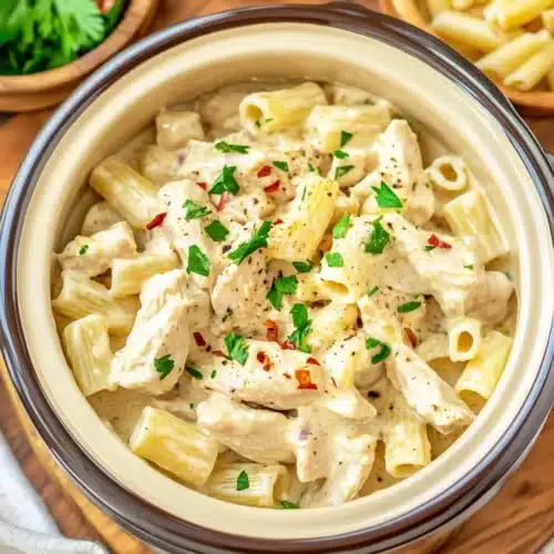 Crock Pot Garlic Parmesan Chicken Pasta 1 Crock Pot Garlic Parmesan Chicken Pasta served with herbs and spices.