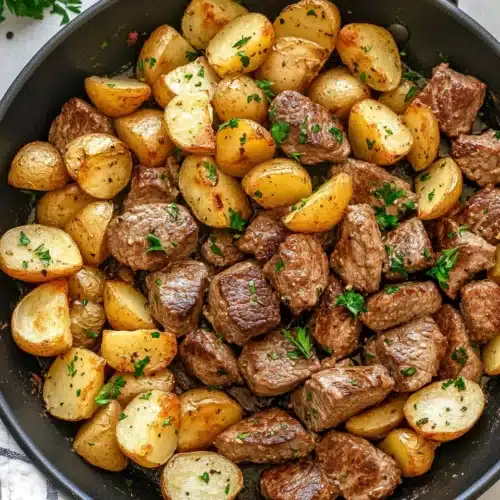 Garlic Butter Steak and Potatoes served in a rustic skillet.