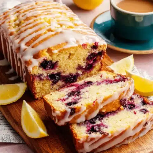 Lemon blueberry bread loaf with glaze and blueberries.