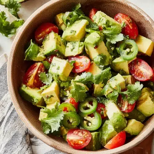 Fresh avocado salad with tomatoes and cilantro.