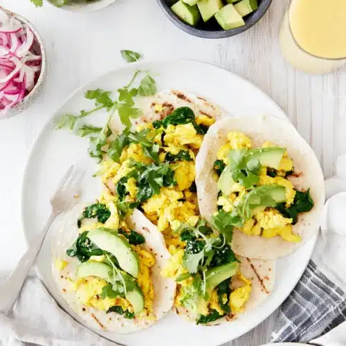 Healthy breakfast featuring scrambled eggs with spinach and avocado