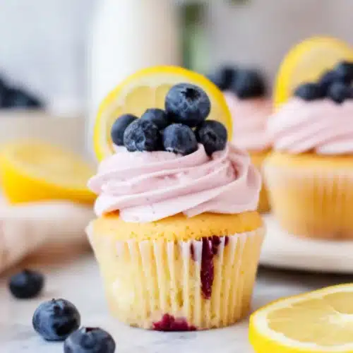 Delicious lemon cupcakes with blueberry buttercream frosting.