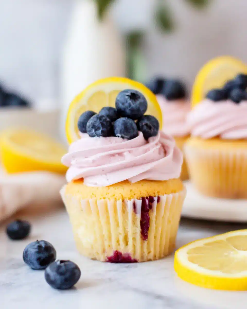 Delicious lemon cupcakes with blueberry buttercream frosting.