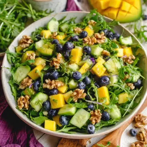 Refreshing mango cucumber salad with arugula and walnuts.
