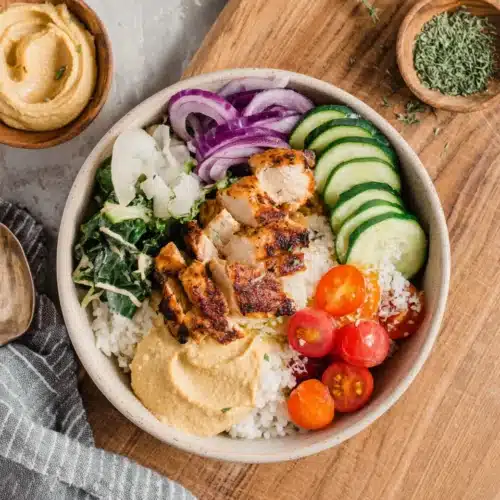 Mediterranean chicken bowls with rice and fresh veggies for a quick meal.