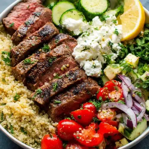 Mediterranean steak bowl featuring fresh veggies and quinoa.