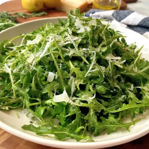 Delicious arugula salad with lemon vinaigrette and Parmesan cheese.