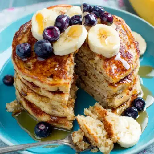 Moist bread free banana oatmeal pancakes stacked with toppings