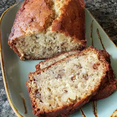 One bowl banana nut bread sliced, served on a plate.