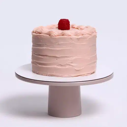 Thiebaud Pink Cake with buttercream frosting and raspberry on top.