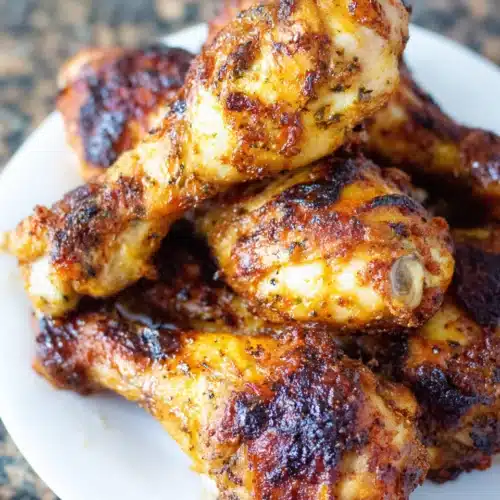 Crispy air fryer chicken drumsticks with honey glaze on a white plate