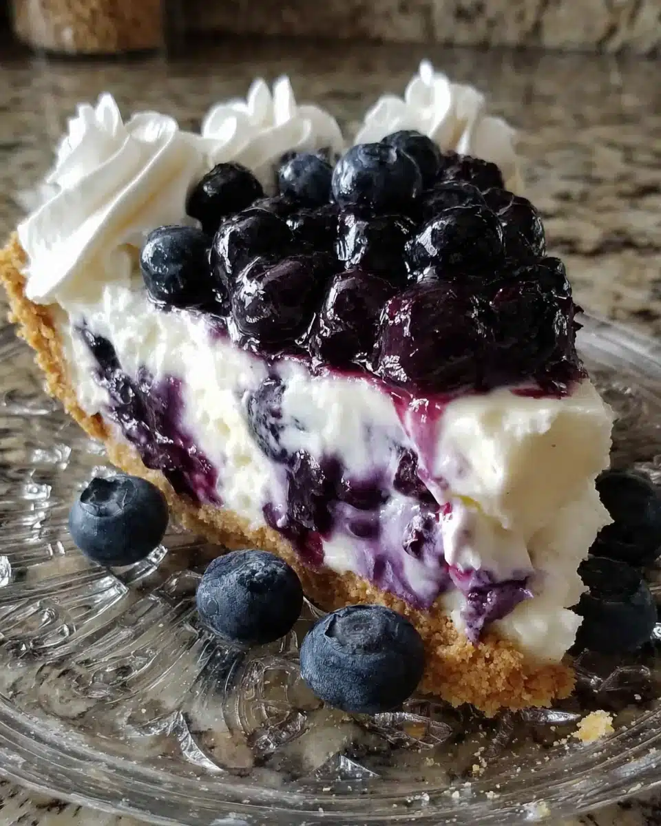 Slice of blueberry cream cheese pie with fresh berries and whipped cream