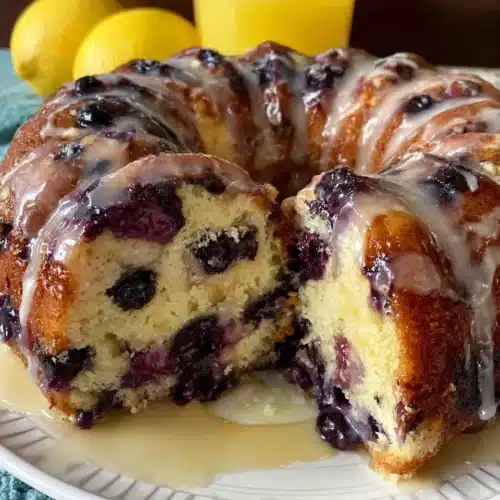 Blueberry sour cream coffee cake with glaze and fresh berries