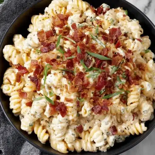 Cheddar Ranch Pasta Salad: A Flavorful Delight 1 Creamy cheddar ranch pasta salad with bacon and green onions in a black bowl