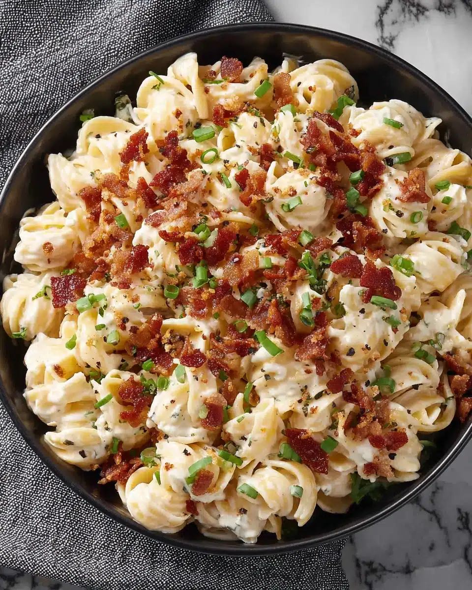 Cheddar Ranch Pasta Salad with Bacon and Green Onions Creamy cheddar ranch pasta salad with bacon and green onions in a black bowl
