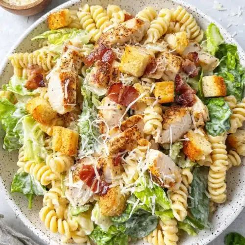 Chicken Caesar Pasta Salad with rotini, chicken, bacon, and parmesan on a plate
