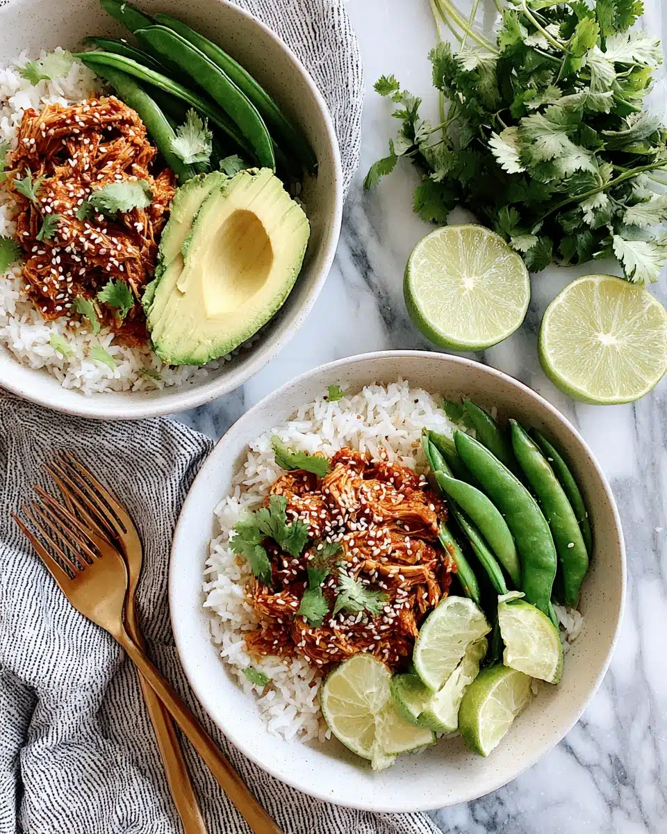 Chicken Recipe with Coconut Rice and Avocado Chicken recipe with coconut rice served with avocado, snap peas, and lime on white plates.