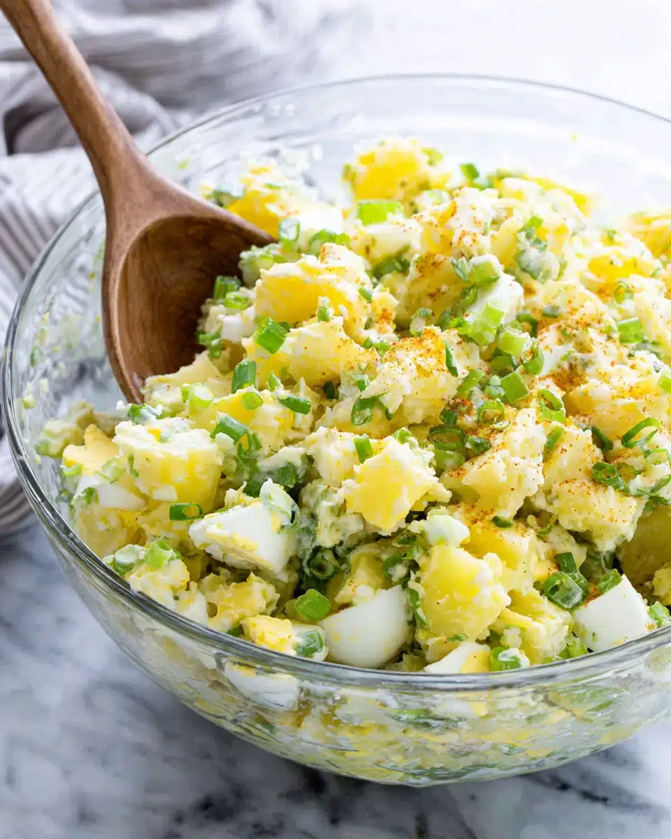 Classic potato salad with eggs and celery in a glass bowl