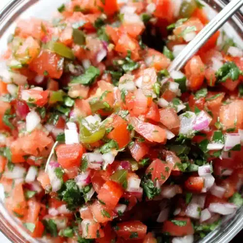 Copycat Chipotle pico de gallo in a glass bowl with fresh tomatoes, onions, and cilantro