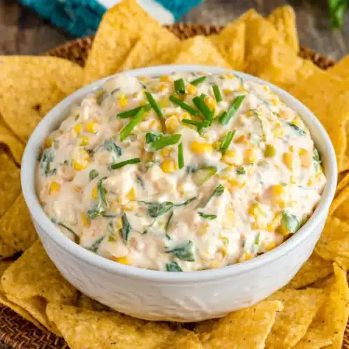 Creamy corn dip with green onions and cheese, served with tortilla chips