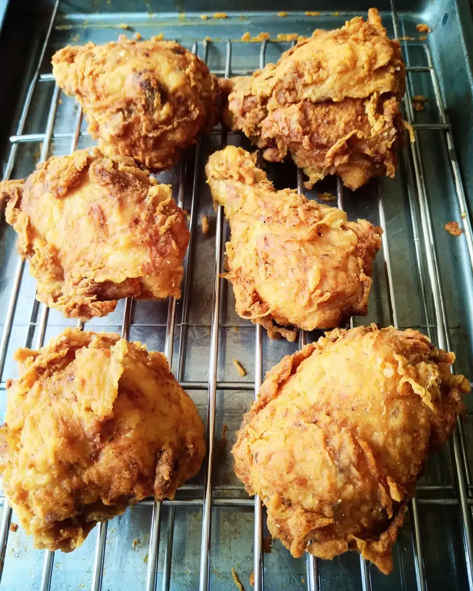 Crispy fried chicken pieces on a cooling rack, golden and crunchy