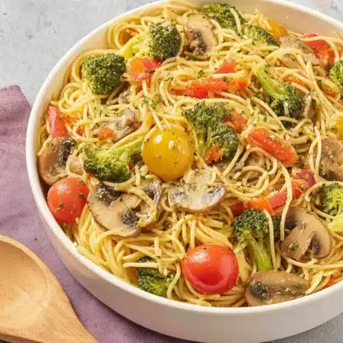 Garlic Pasta Salad: A Delicious and Easy Side Dish 1 Garlic pasta salad with fresh vegetables and mushrooms in a white bowl