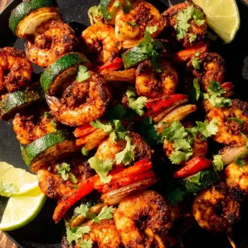Grilled BBQ Shrimp Kabobs: A Flavorful Delight 1 Grilled BBQ shrimp kabobs with vegetables and lime on a plate