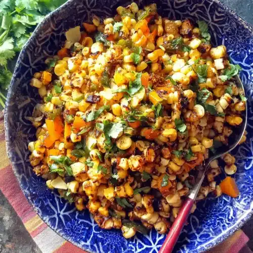 Grilled Summer Chipotle Corn Salad: A Smoky Delight 1 Grilled summer chipotle corn salad in a blue bowl with fresh herbs and charred vegetables