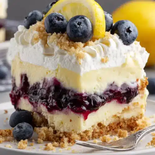 Lemon Blueberry Lush: A Delightfully Refreshing Dessert 1 Lemon Blueberry Lush dessert slice with graham cracker crust, creamy lemon, blueberry layer, and whipped cream