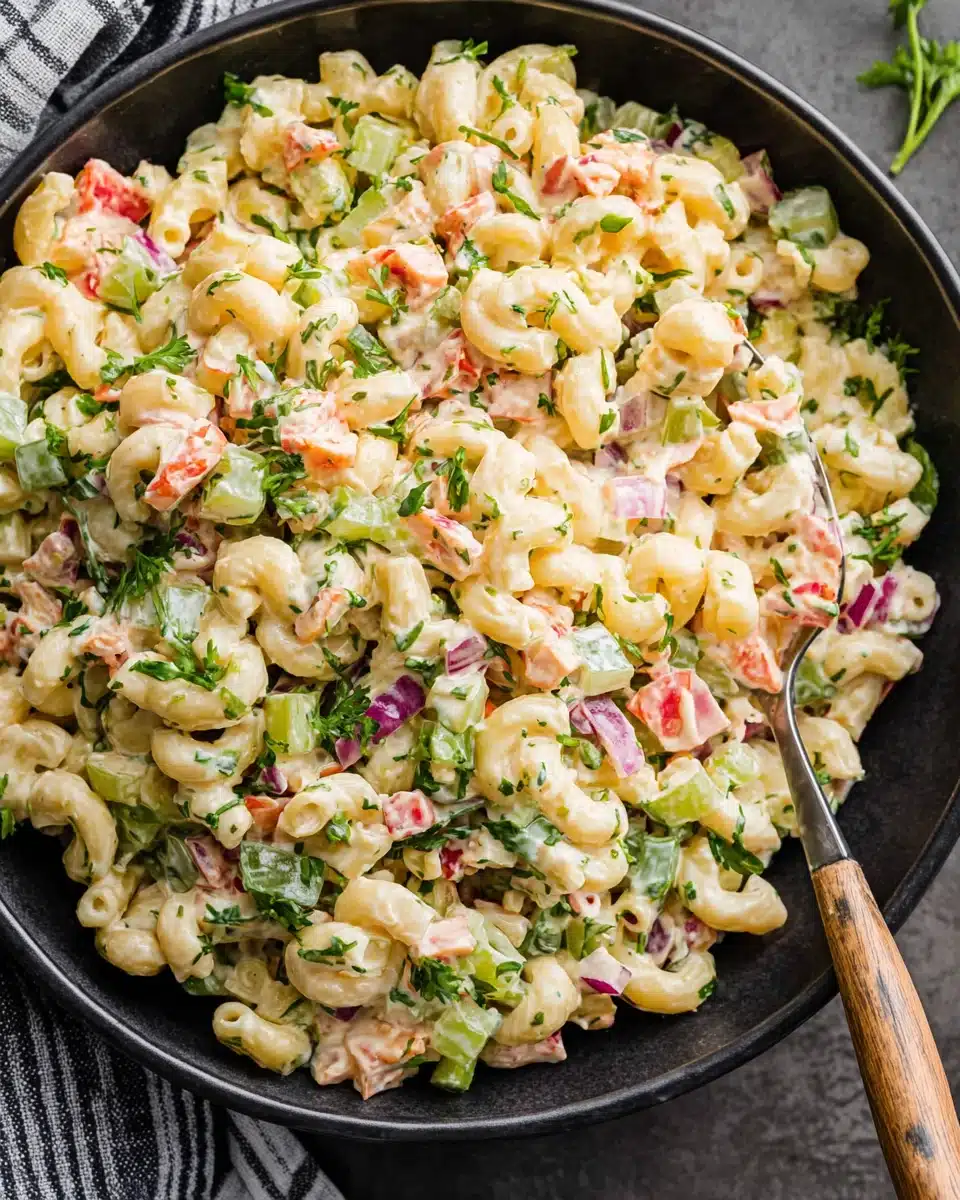 Creamy macaroni salad with colorful veggies in a black bowl