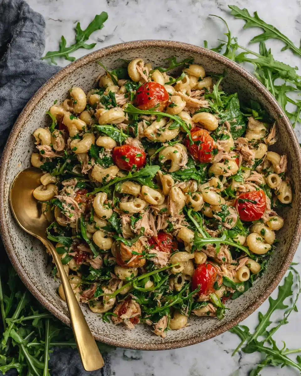 Make ahead tuna pasta salad with roasted tomatoes, arugula, and herbs in a bowl