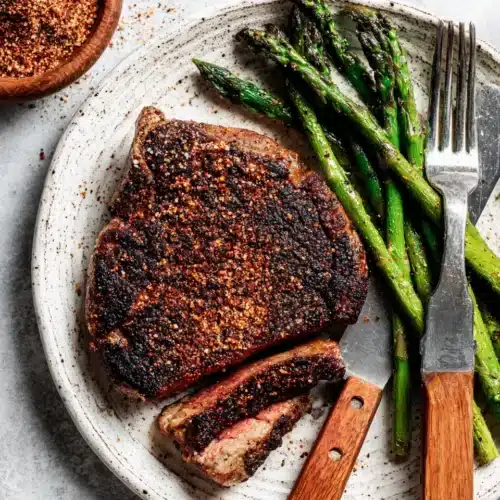 Juicy pellet grill steak with asparagus and dry rub on a plate