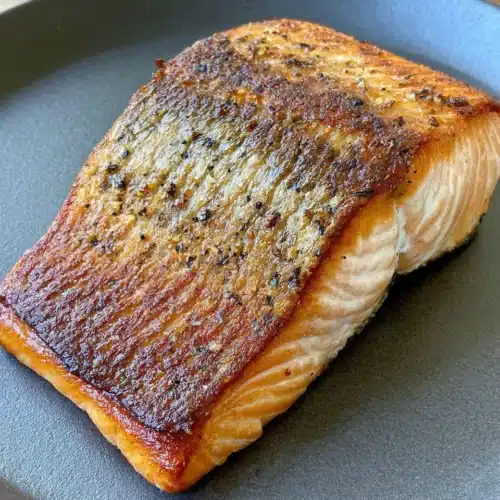 Perfectly pan seared salmon with crispy skin on a gray plate