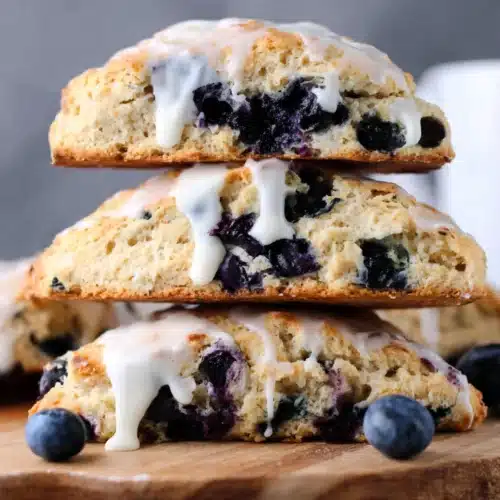 Sourdough Blueberry Scones: Delightfully Flaky and Sweet 1 Stack of sourdough blueberry scones with vanilla glaze and fresh blueberries