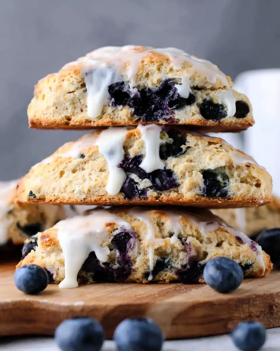 Sourdough Blueberry Scones with Vanilla Glaze Stack of sourdough blueberry scones with vanilla glaze and fresh blueberries
