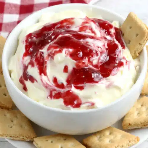 Strawberry Cheesecake Dip: A Delightful Treat 1 Strawberry cheesecake dip in a white bowl with graham crackers