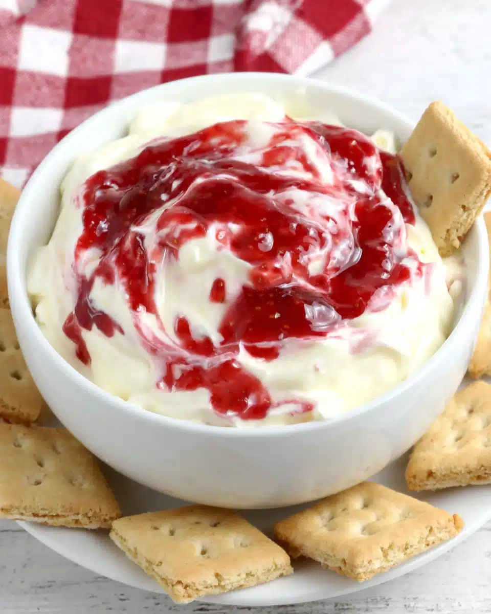 Strawberry Cheesecake Dip with Graham Crackers Strawberry cheesecake dip in a white bowl with graham crackers