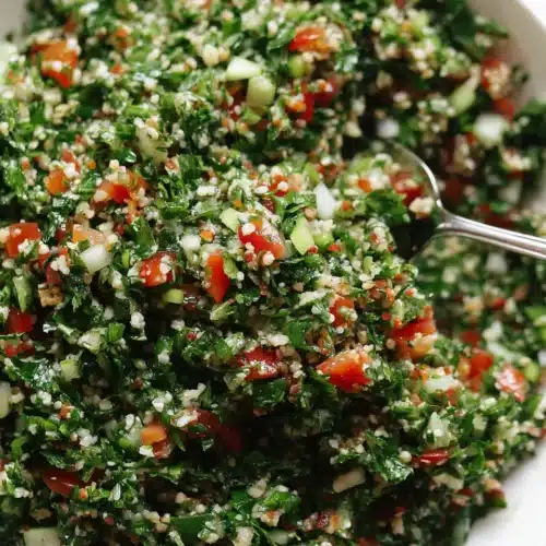 Fresh tabouli salad with bulgur, parsley, mint, tomatoes, and green onions in a white bowl