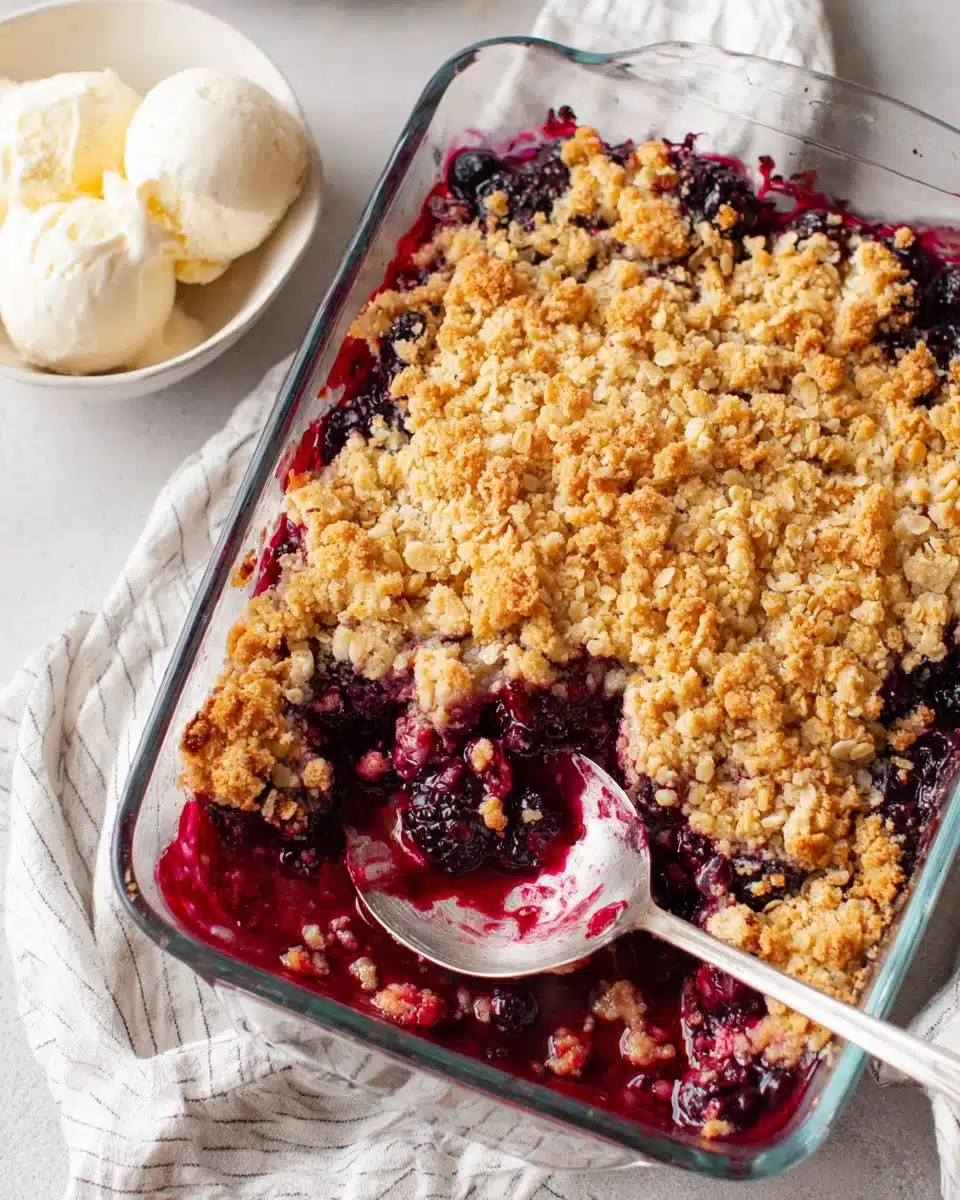 Triple berry crisp with golden crumble topping and juicy berry filling, served with vanilla ice cream