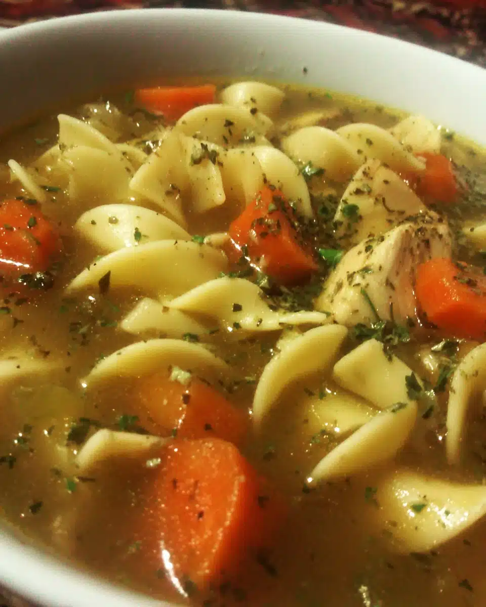 Hearty Tuscan chicken noodle soup with noodles, carrots, and herbs