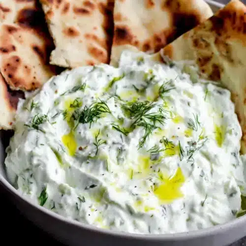 Easy Vegan Tzatziki Recipe for Fresh Flavor 1 Creamy vegan tzatziki with dill and pita bread, served in a bowl