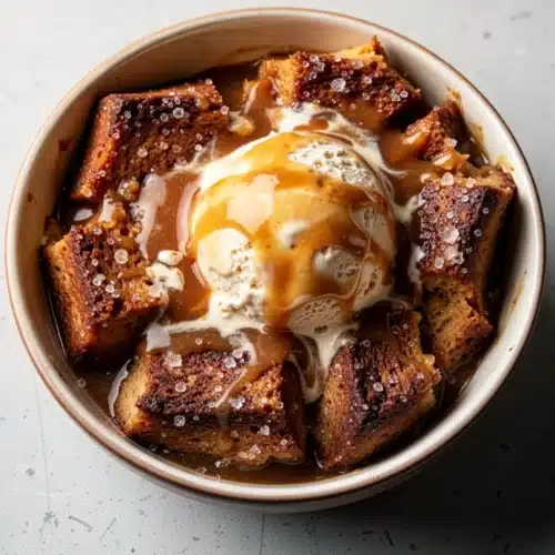 Brûléed bread pudding with butterscotch sauce and vanilla ice cream in colorful bowls