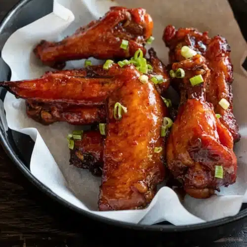 Chicken Wing Sauce: Deliciously Easy and Versatile 2 Glossy chicken wing sauce coating crispy wings with green onion garnish